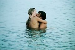 Молодая девушка купается в море со своим парнем
